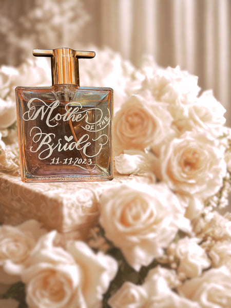Perfume bottle with 'Mother of the Bride' engraving on a bed of white roses.
