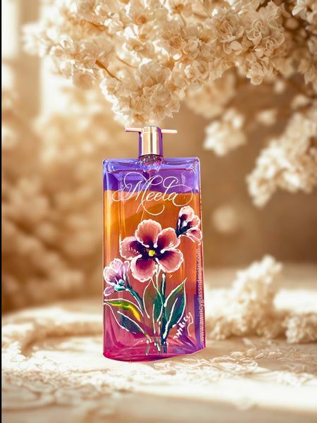 Lancome Idôle perfume bottle engraved and hand-painted with five-petal florals in soft pink, yellow, and purple hues with green leaves — a modern, luxury personalized perfume bottle for brides, bridesmaids, and mothers of the bride, crafted by A Wincy Glass ’N Design
