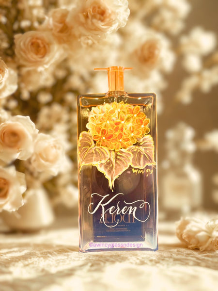 Lancome Idôle perfume bottle engraved and hand-painted with soft peach hydrangea blooms accented by white leaves and raised gold detailing — a luxury bridal perfume bottle handcrafted for brides, bridesmaids, and mothers of the bride by A Wincy Glass ’N Design