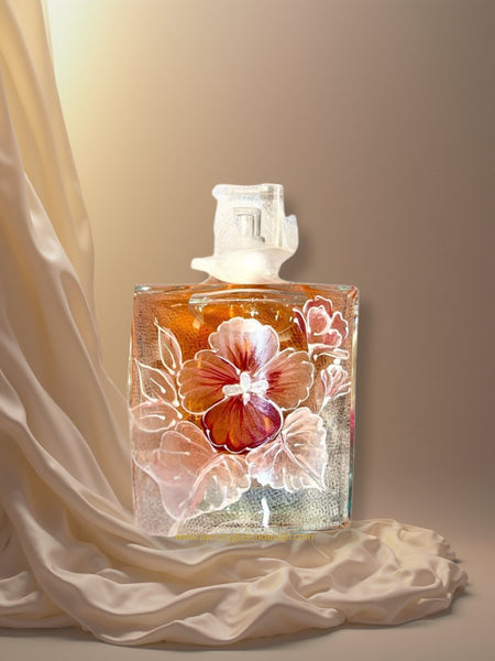 Closeup of a Lancome La Vie Est Belle perfume bottle hand-painted with pink and silver shimmer pansy florals — a luxury personalized perfume bottle for brides, bridesmaids, and mothers of the bride, crafted by A Wincy Glass ’N Design
